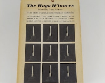 May include: The Hugo Winners book cover features a title in bold font and a list of authors. The cover is beige with a grid of nine black and white images of rockets.