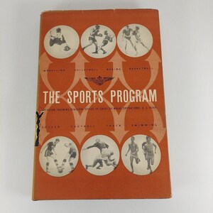Op de afbeelding: Een vintage boekomslag met een oranje achtergrond en illustraties van atleten die deelnemen aan verschillende sporten, waaronder worstelen, volleybal, boksen, basketbal, voetbal, atletiek en zwemmen. De titel van het boek is "The Sports Program" en de tekst eronder luidt "Aviation Training Division Office of Chief of Naval Operations, U.S. Navy".