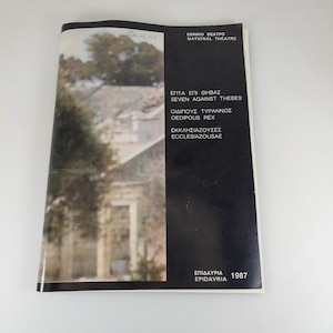 Peut inclure: Un programme de théâtre vintage avec une photo d'un bâtiment en pierre et d'arbres en couverture. Le titre est en grec et en anglais, avec des pièces comme "Seven Against Thebes" et "Oedipus Rex". L'année "1987" est imprimée en bas à droite.