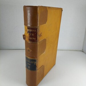 Op de afbeelding: Een bruin lederen gebonden boek met de titel "Pennsylvania State Reports" en het nummer "40" op de rug. Het boek is licht beschadigd en heeft een verbleekte gele kleur.