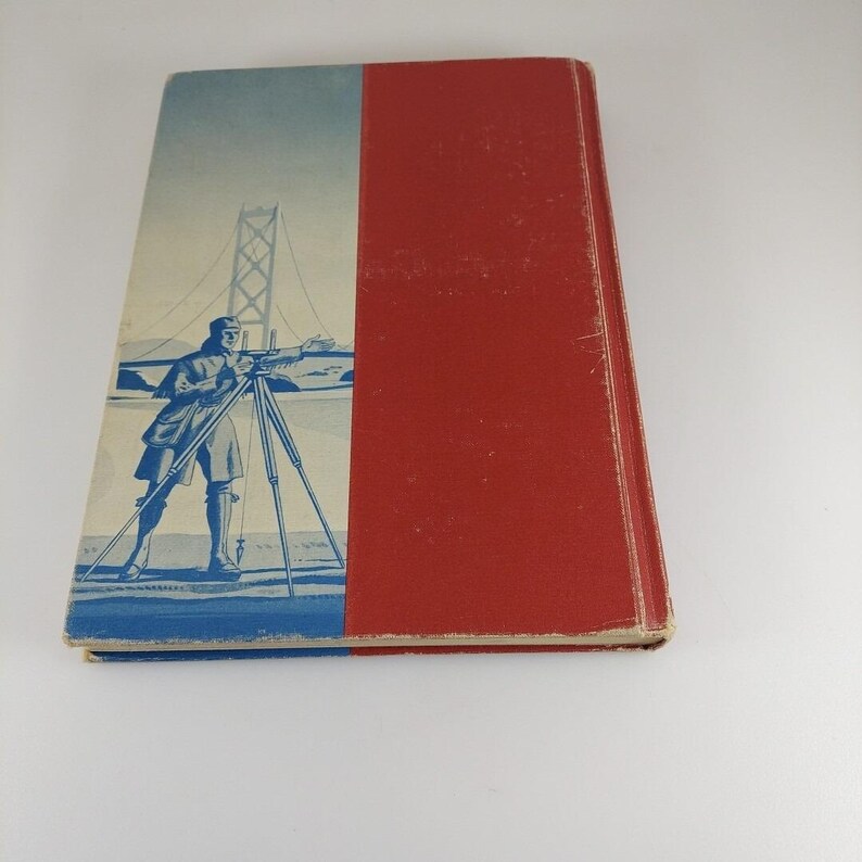 Puede incluir: Un libro vintage con una cubierta azul y roja. La portada presenta una ilustraci&oacute;n azul de un hombre usando un instrumento de medici&oacute;n frente a un puente.