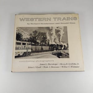 May include: A vintage book titled "WESTERN TRAINS" by Richard Steinheimer and Donald Sims. The cover shows a black and white photograph of a train with smoke. The book also lists contributing photographers.