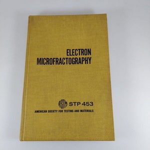 May include: A yellow book titled "Electron Microfractography" with the text "ASTM STP 453" and "American Society for Testing and Materials" printed on the cover.