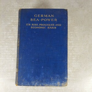 May include: A blue hardcover book with the title "GERMAN SEA-POWER ITS RISE, PROGRESS AND ECONOMIC BASIS" in gold lettering.