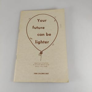 May include: A vintage pamphlet with the text "Your future can be lighter" inside a balloon illustration. The pamphlet is beige and includes the text "1000 CALORIE DIET" and the name of a medical center.