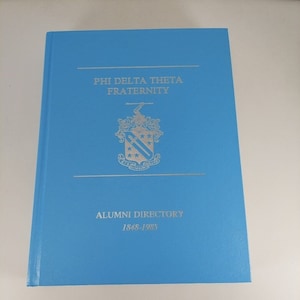 May include: A light blue book with the title "Phi Delta Theta Fraternity Alumni Directory 1848-1985" printed in silver lettering.