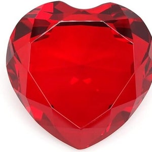 May include: A large, red, heart-shaped crystal paperweight. The crystal is faceted and has a high shine.