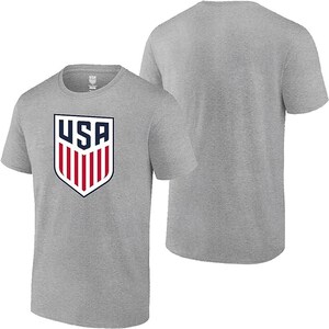 May include: A heather grey t-shirt with a white and red USA crest on the front. The shirt has short sleeves and a crew neck.