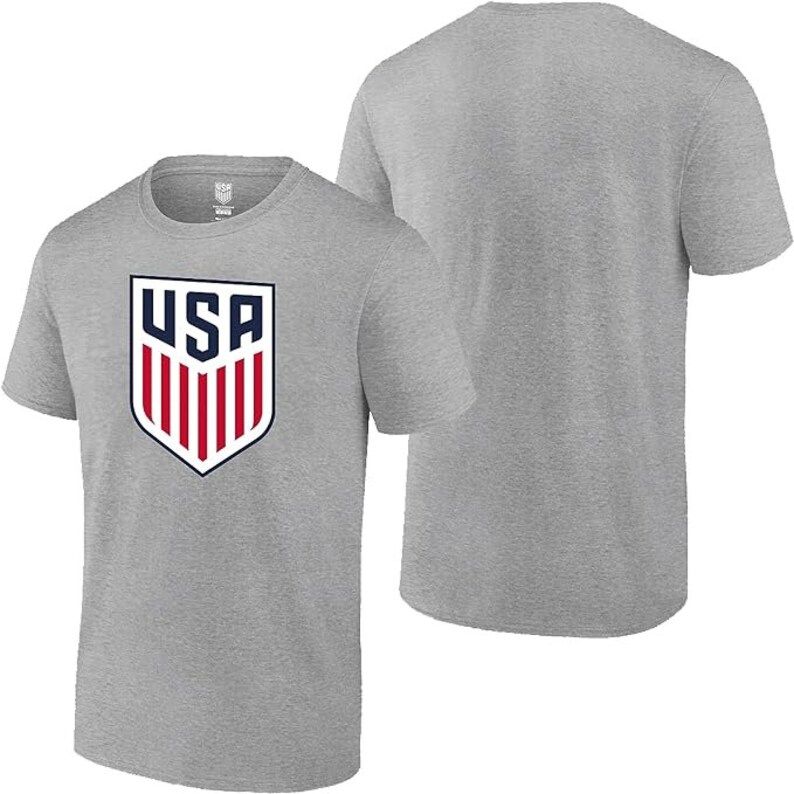 May include: A heather grey t-shirt with a white and red USA crest on the front. The shirt has short sleeves and a crew neck.