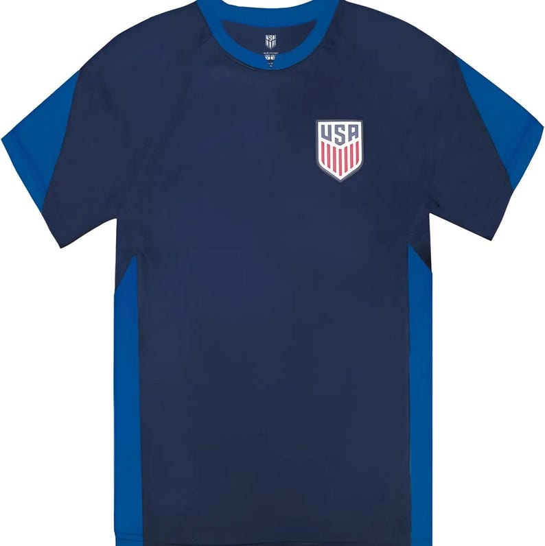 Pu&ograve; includere: T-shirt sportiva blu navy con dettagli blu sulle maniche e sui lati. Presenta uno stemma USA sul petto. La maglietta a maniche corte ha uno scollo tondo.