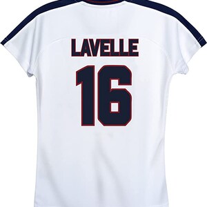 May include: White soccer jersey with navy blue and red trim. The back of the jersey has the name "LAVELLE" and the number "16" printed in navy blue with a red outline.