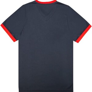 May include: A navy blue t-shirt with red trim around the collar and sleeves.