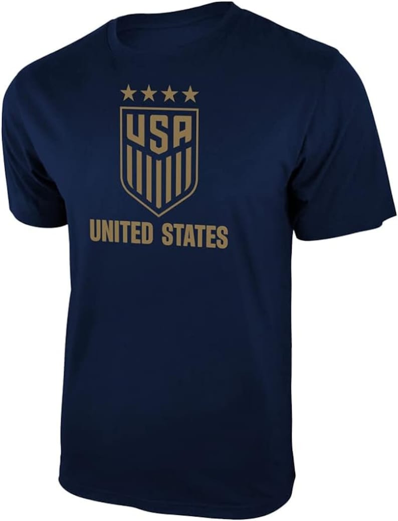 Puede incluir: Una camiseta azul marino con un gr&aacute;fico dorado de la bandera de los Estados Unidos y el texto "UNITED STATES".