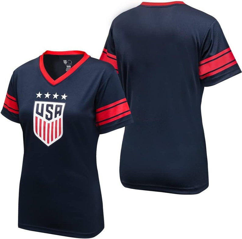 May include: Navy blue short-sleeved jersey with red and white stripes on the sleeves. The jersey has a white "USA" logo with red stripes and five white stars above the logo.