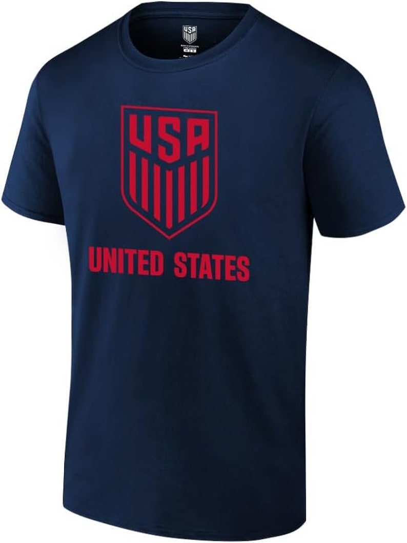 Puede incluir: Una camiseta azul marino con un logotipo de EE. UU. rojo y las palabras "UNITED STATES" impresas en la parte delantera.