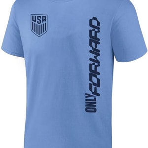 K&ouml;nnte beinhalten: Hellblaues T-Shirt mit einem dunkelblauen USA-Logo auf der linken Brust und "ONLY FORWARD" vertikal auf der rechten Seite gedruckt.
