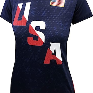 May include: A navy blue short-sleeved t-shirt with a white and red diagonal "USA" graphic and a small American flag on the right shoulder.