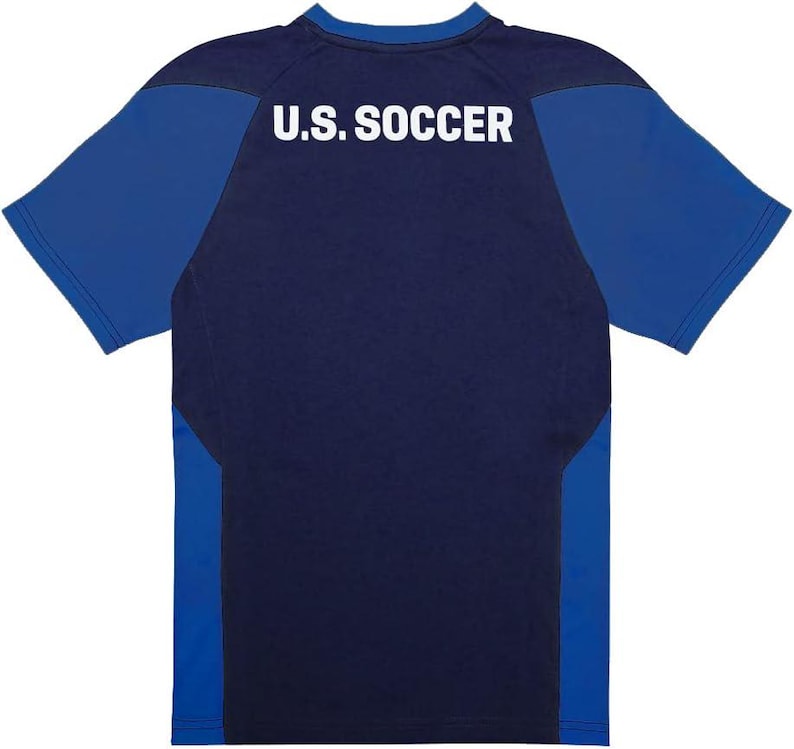 Pu&ograve; includere: Maglia da calcio blu navy e blu reale. La parte posteriore della maglia presenta la scritta "U.S. SOCCER" in lettere bianche. La maglia ha maniche corte e girocollo.