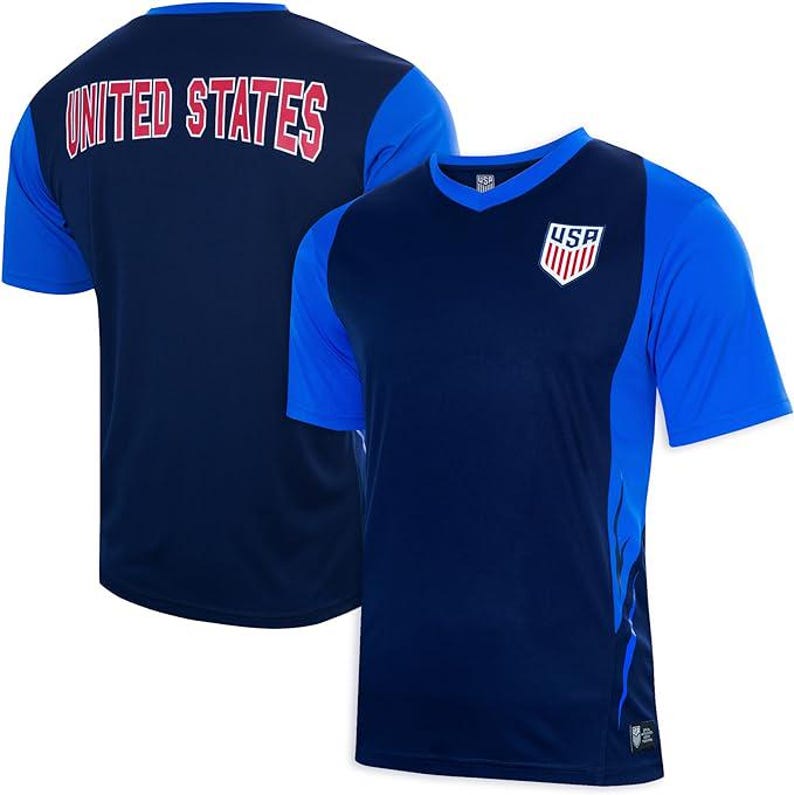 Pode incluir: Duas camisas de futebol azul marinho com detalhes em vermelho e branco. A camisa da frente tem um logotipo dos EUA azul e branco no peito. A camisa de tr&aacute;s tem "UNITED STATES" impresso em vermelho nas costas.