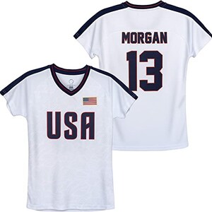 Puede incluir: Camiseta de f&uacute;tbol blanca con detalles en azul y rojo. La camiseta tiene la palabra "USA" impresa en la parte delantera y una peque&ntilde;a bandera estadounidense. La parte posterior de la camiseta tiene el nombre "MORGAN" y el n&uacute;mero "13" impreso en azul.
