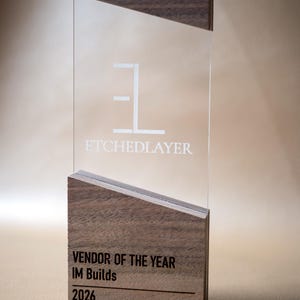 May include: A clear acrylic award with a wooden base and top. The text "ETCHEDLAYER" is etched into the acrylic. The base reads "VENDOR OF THE YEAR IM Builds 2026".