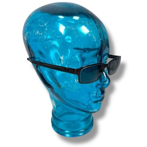 May include: Black rectangular sunglasses with blue lenses on a blue mannequin head.