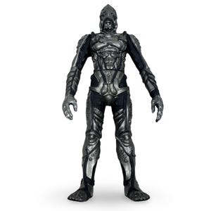 May include: A silver and black action figure of a humanoid robot. The figure has a detailed, armored design with a helmet, segmented limbs, and intricate detailing. The figure is standing with arms outstretched.