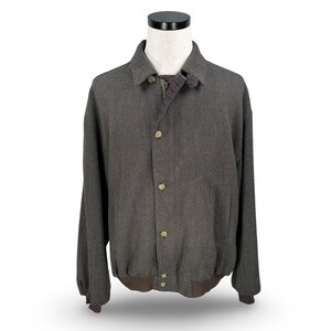 May include: A dark gray wool jacket with a button-up front, a collar, and a brown ribbed hem and cuffs. The jacket has gold-colored buttons and a patterned lining visible at the collar.