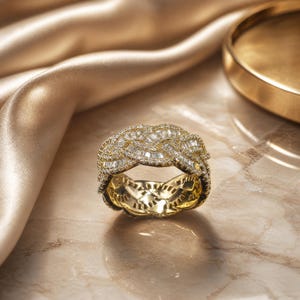 May include: A gold ring featuring a wide, braided band design. The surface of the ring is densely encrusted with numerous small, clear, rectangular baguette-cut stones that cover the entire outer circumference of the braided metal structure.