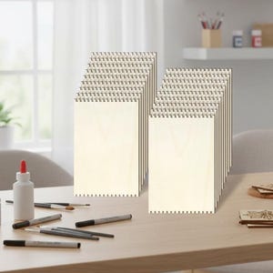 May include: A collection of rectangular light-colored wooden panels featuring notched edges along the top and bottom. These flat, unfinished wood pieces are arranged in two vertical stacks, showcasing a smooth surface and a consistent light grain.