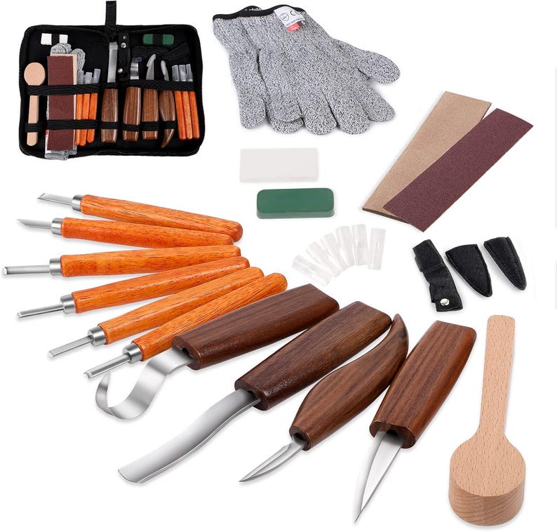 May include: A wood carving set with various tools, including knives, gouges, and a spoon-shaped tool. The set includes a protective glove, sharpening stones, and sandpaper. The tools have wooden handles and stainless steel blades, and are arranged on a white surface.