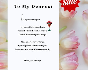 May include: A white card with black text that reads "To My Dearest i appreciate you. My cup of love overflows with the best thoughts of you. Let me hold onto you always. My cup of joy overflows. My happiness flows out to you. Cheers to our beautiful relationship. I love you, always."  A red star with the word "Sale" is in the upper right corner of the image.