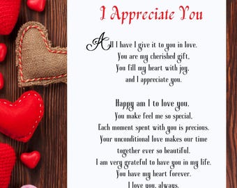 May include: A white card with red text that reads "I Appreciate You". The card has a poem about love and appreciation. The card is surrounded by red and pink felt hearts on a wooden background.