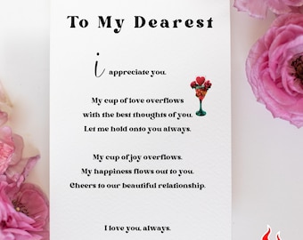 May include: A white card with black text that reads "To My Dearest i appreciate you. My cup of love overflows with the best thoughts of you. Let me hold onto you always. My cup of joy overflows. My happiness flows out to you. Cheers to our beautiful relationship. I love you, always." There is a small image of a cocktail glass with hearts and a red and green straw.