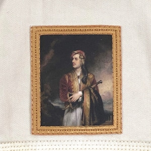 May include: A framed portrait of a man in a red and gold uniform, wearing a red fez hat. The portrait is set against a dark background with a landscape in the distance.