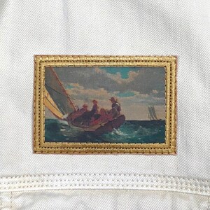 May include: A framed painting of a sailboat with people on board, sailing on a body of water with a cloudy sky in the background.