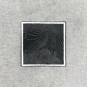 May include: Black and white embroidered patch with a topographic map design. The patch has a white border.
