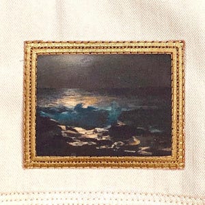 May include: A framed image of a seascape at night with waves crashing on the shore. The image is in a gold frame with a decorative border.