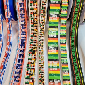 May include: Assortment of colorful ribbon with various designs and text. The ribbons feature the words "Juneteenth" and "Freedom Day" in a variety of fonts and colors.