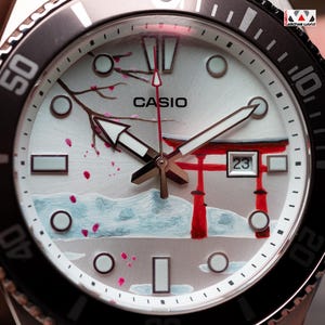 May include: A set of three ceramic mugs with a speckled, matte finish. The mugs are in shades of cream, light gray, and dark gray. Each mug has a simple, minimalist design and a rounded handle.