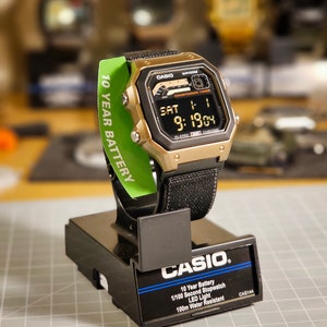 Reloj modificado basado en el Casio WS-1600, pantalla LCD polarizada mitad negativa, caja color bronce hidromod y correa de repuesto elástica negra de 22 mm.