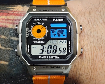 Casio AE-1200 Modified. Color filtered LCD watch on orange elastic strap.