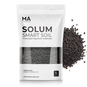 Peut inclure: Un sac blanc de substrat d'aquarium noir étiqueté "Solum Smart Soil" par Modern Aqua. Le sac est de 3 litres (6 lb) et conçu à Oakland, USA. Un tas de substrat noir est présenté dans le coin supérieur droit de l'image.