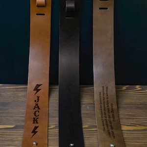 May include: Three leather straps in brown, black, and tan, each with unique engraved text. The brown strap features the name "JACK" with lightning bolt symbols. The black strap says "Happy 3rd Anniversary". The tan strap has a quote by Freddie Mercury.