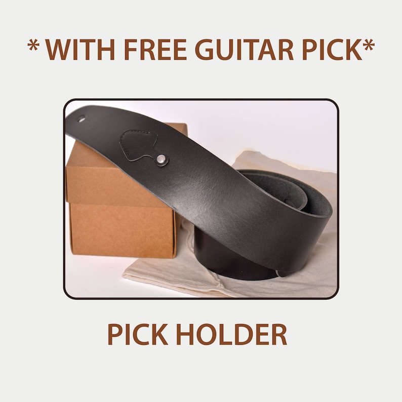 May include: Black leather guitar strap with a pick holder, displayed with a brown cardboard box and a white cloth. The text "PICK HOLDER" is at the bottom of the image.