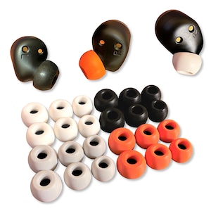 May include: An assortment of replacement ear tips in various colors and sizes. The image shows black, white, gray, and orange ear tips, along with black earbud housings marked with "L" and "R".