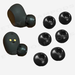 May include: Black replacement ear tips and earbuds. The image shows several black earbud tips and two black earbuds. The earbud tips are round with a mesh screen. The earbuds have a rounded shape with a small ear tip.
