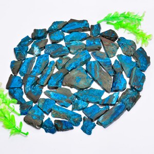 May include: A collection of raw, natural stones with a striking blue and gray color palette. The stones vary in size and shape, with a rough, textured surface. The arrangement of the stones creates a visually appealing display, suitable for jewelry making or decorative purposes.