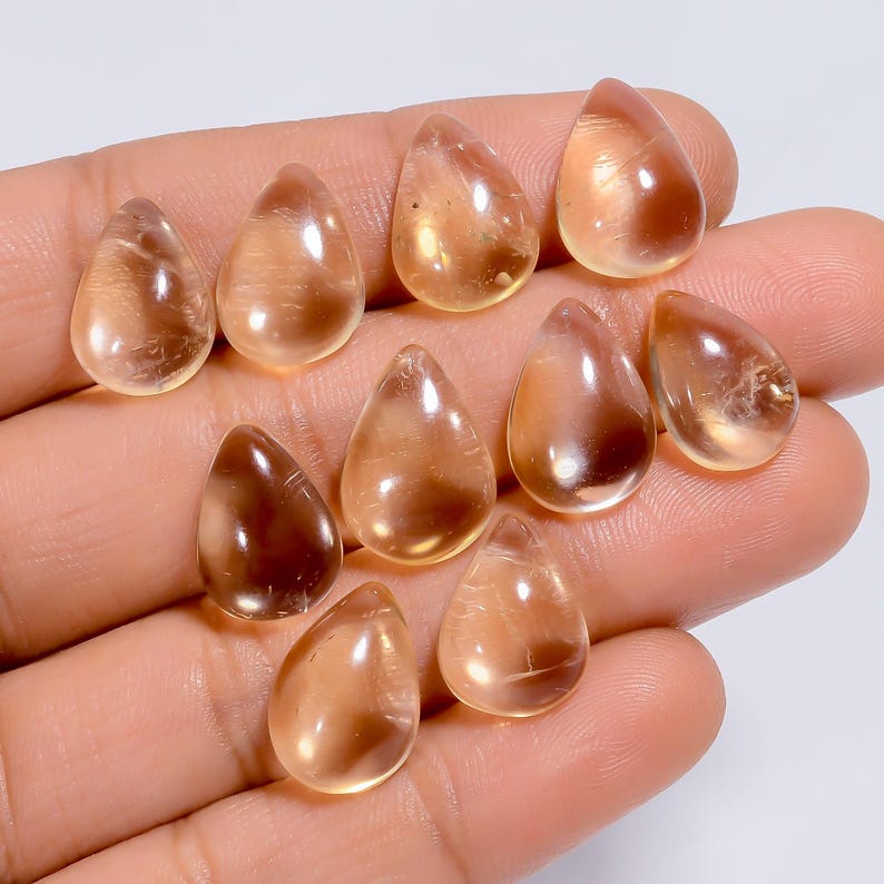 May include: Ten teardrop-shaped, translucent, light amber gemstones. The gemstones are smooth and polished.