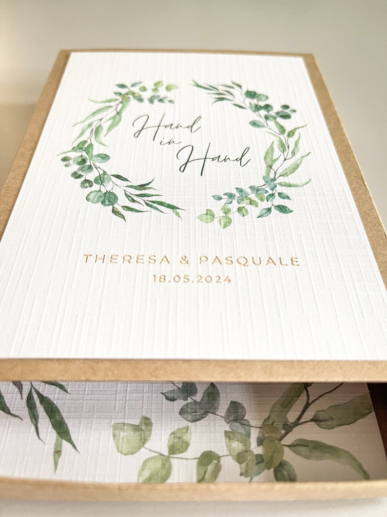 Personalisierte Geschenkschachtel als Geldgeschenk zur Hochzeit im Greenery Design mit Eukalyptus.Die Schiebeschachtel ist aus hochwertigem Kraftpapier und kann dem Brautpaar nach der Hochzeit noch als Aufbewahrung von Fotos dienen.